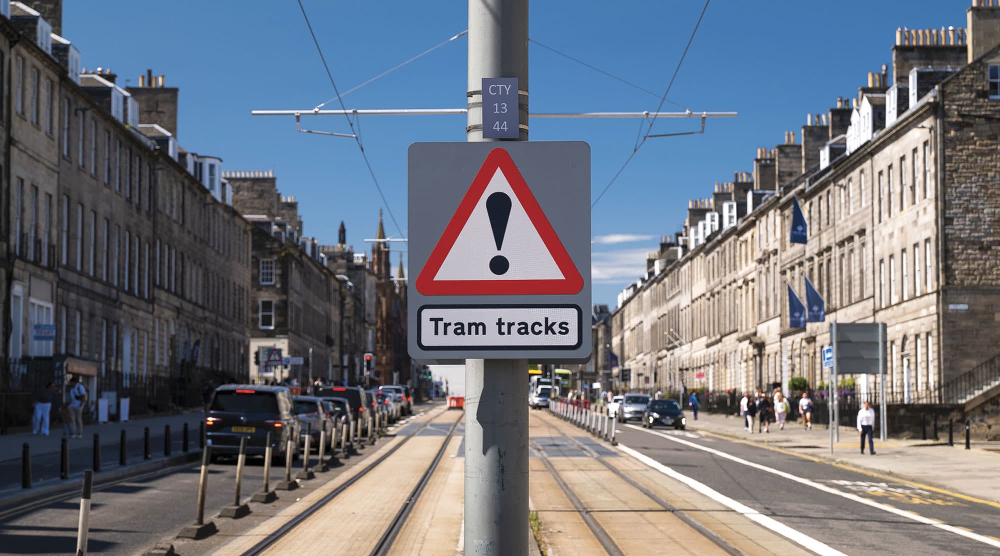 A warning sign for tram tracks on a sunny Georgian street in Edinburgh